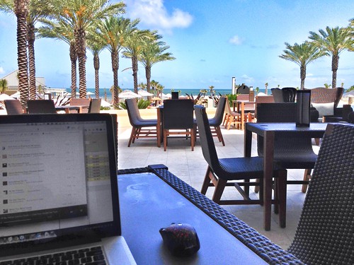 Photo of someone working poolside at a resort